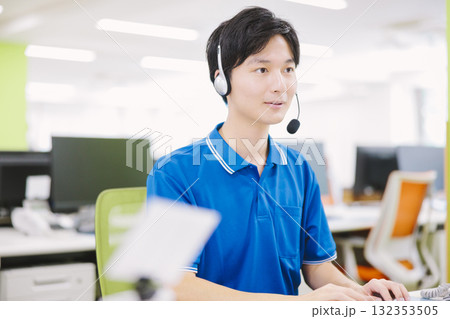ヘッドセットをつけてコールセンターで働く男性 132353505