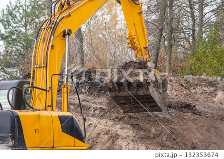 Digging soil with excavator. Close up of shovel of excavator with soil 132353674