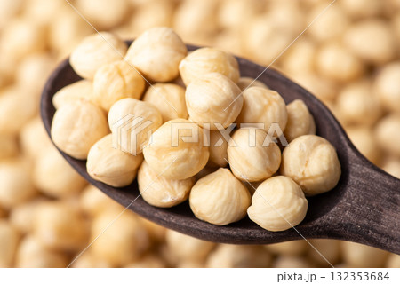 Dark wooden spoon with peeled hazelnuts. Fresh tasty hazelnuts close up Dark wooden spoon with peeled hazelnuts. Fresh tasty hazelnuts close up 132353684