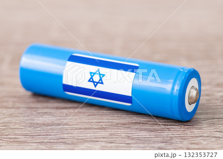 Rechargeable battery with flag of Israel on table. Origin of battery, produce accumulators in Israel Rechargeable battery with flag of Israel on table. Origin of battery, produce accumulators in Israel 132353727