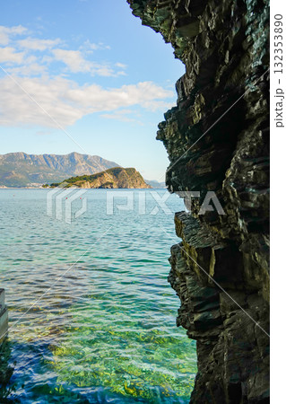 View of the Adriatic Sea near Budva, Montenegro, with a coastal rock occupying half of the frame. Scenic seascape with natural rock formations and calm waters. 132353890