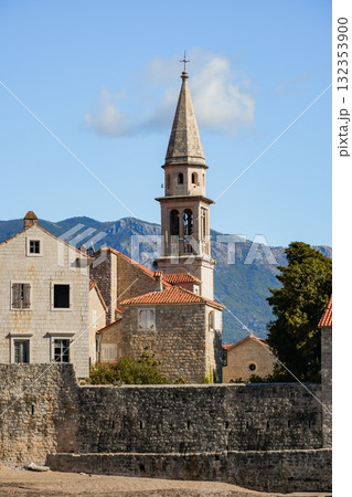 Close-up view of Budva Old Town and its historic tower from the waterfront. Detailed coastal cityscape with Adriatic Sea in the background. 132353900