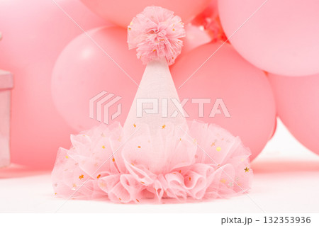 Pink tulle hat surrounded by balloons, cute feminine decor for baby girls first birthday photo shoot. 132353936