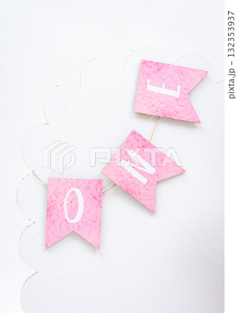 Pink felt banner with letters ONE hanging on white background, simple and stylish first birthday decoration for baby girl 132353937