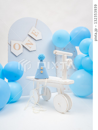 Blue balloons, wooden ONE banner, and small tricycle create soft pastel first birthday setup, perfect for boys milestone celebration Blue balloons, wooden ONE banner, and small tricycle create soft pastel first birthday setup, perfect for boys milestone celebration 132353939