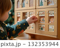A hand of kid girl open wooden advent calendar for a Christmas 132353944
