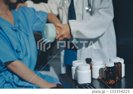Physical therapist assisting a woman with dumbbell exercise Physical therapist assisting a woman with dumbbell exercise 132354225