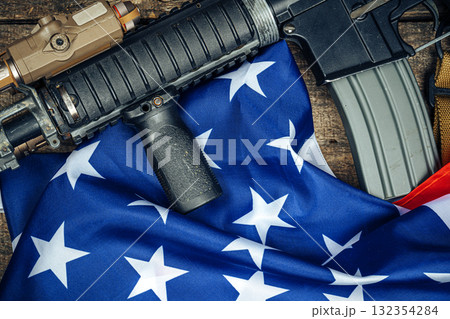 U.S. battle flag and assault rifle on the wooden table. 132354284
