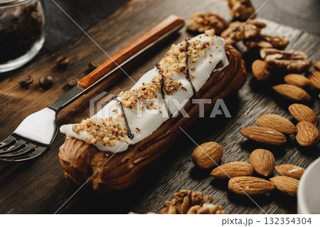 Eclair cake on dark wooden board on black table Eclair cake on dark wooden board on black table 132354304