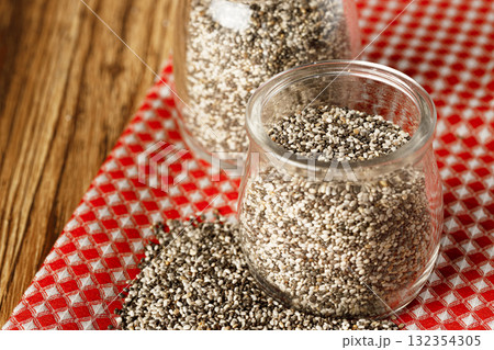 Glass bowl with chia seeds on wooden table Glass bowl with chia seeds on wooden table 132354305