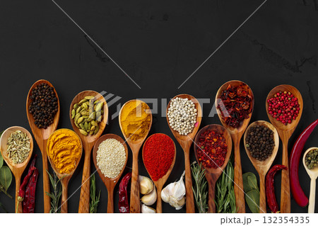 Various exotic spices in wooden spoons on dark background Various exotic spices in wooden spoons on dark background 132354335