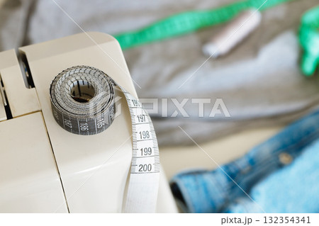 Woman tailor making measurements with measuring tape in her office 132354341