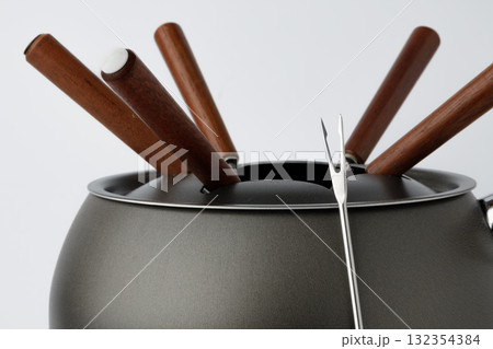 Metal cookware for fondue preparation on white Metal cookware for fondue preparation on white 132354384
