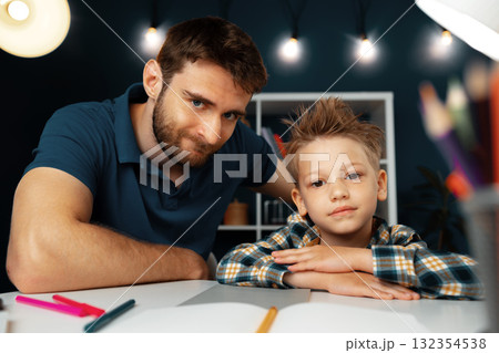 Dad and son doing school homework together Dad and son doing school homework together 132354538