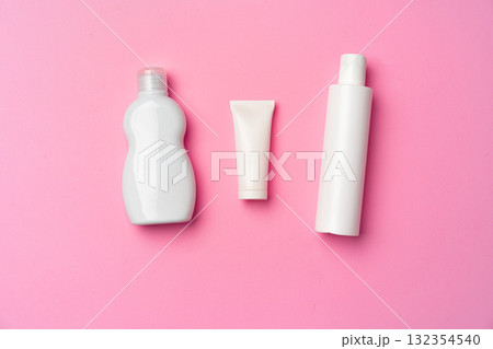 Three white cosmetic bottles on pink background flat lay 132354540