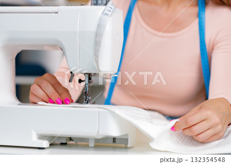 Woman seamstress working at textile factory close up Woman seamstress working at textile factory close up 132354548