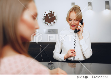 Female receptionist in hotel talking on the phone at work 132354568