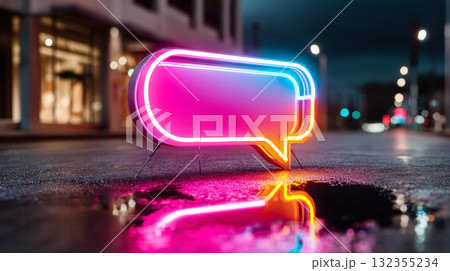 A glowing neon speech bubble sign on a city street at night, reflecting in the puddle of water below it A glowing neon speech bubble sign on a city street at night, reflecting in the puddle of water below it 132355234