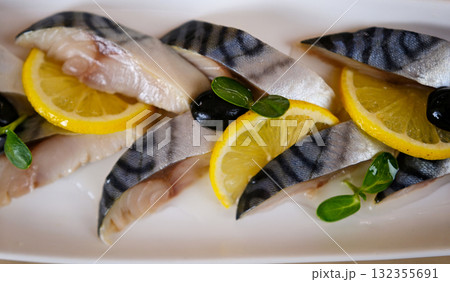 Fish dish cooking with various ingredients. Raw mackerel with lemon, garlic, herbs and spices on cutting board, top view. Healthy food or diet nutrition concept 132355691