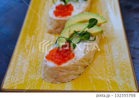 red caviar Rye bread slice with smoked salmon and avocado isolated on white background 132355708