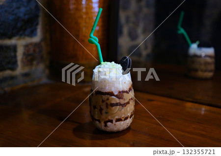 Chocolate milkshake with whipped cream on light green background. Coffee creamy dessert with chocolate.  132355721