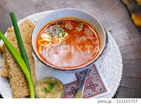 Tomato soup with cream in a white bowl. Grey background. Close up. Tomato soup with cream in a white bowl. Grey background. Close up. 132355737