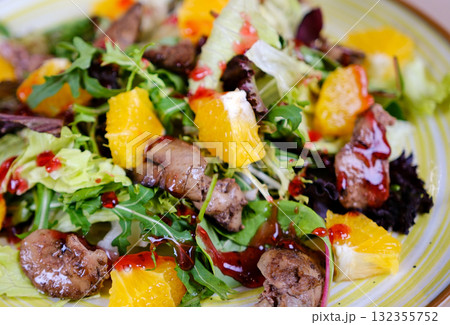 Salad with liver, oranges, herbs, cherry sauce, cranberry sauce, and arugula duck liver, juicy orange nuts. A vibrant, healthy dish perfect for restaurant menus, food blogs, and culinary concepts. 132355752