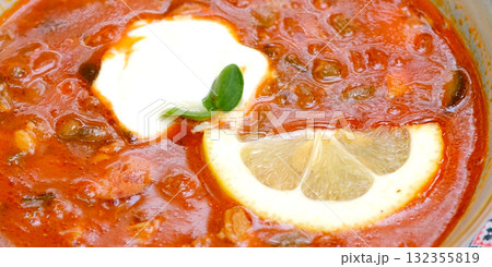 A Delicious Bowl of Tomato Soup Garnished with Fresh Lemon and Accompanied by Crispy Bread and Cherry Tomatoes on a Rustic Black Slate Surface A Delicious Bowl of Tomato Soup Garnished with Fresh Lemon and Accompanied by Crispy Bread and Cherry Tomatoes on a Rustic Black Slate Surface 132355819