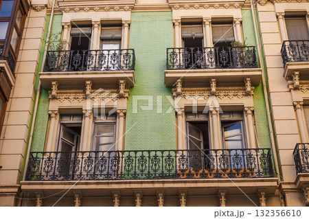 Historic Art Nouveau facade with decorative balconies and green ceramic tiles in Alicante, Spain 132356610
