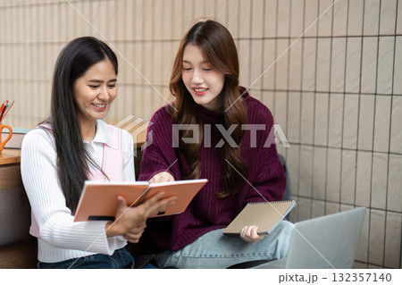 Studying Together and Bonding. Students collaborating on coursework, sharing notes and ideas in a relaxed atmosphere. 132357140