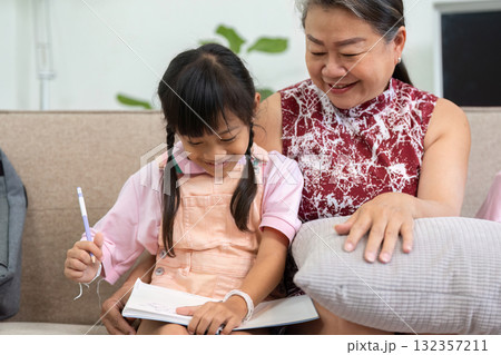 Back to School and Artistic Expression. A young girl enjoys drawing with her grandmother's support. 132357211