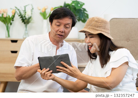 Travel and Retirement. A happy elderly couple exploring travel options on a tablet together. 132357247