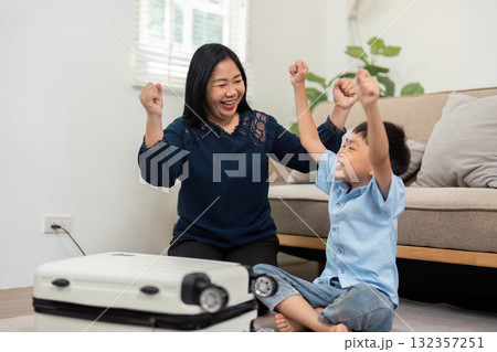 Celebration and Family Joy. A mother and son celebrate packing completion for their family trip. Celebration and Family Joy. A mother and son celebrate packing completion for their family trip. 132357251