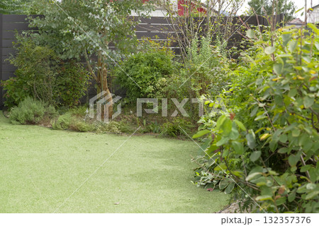 緑豊かな植栽と人工芝の庭のある住宅 132357376