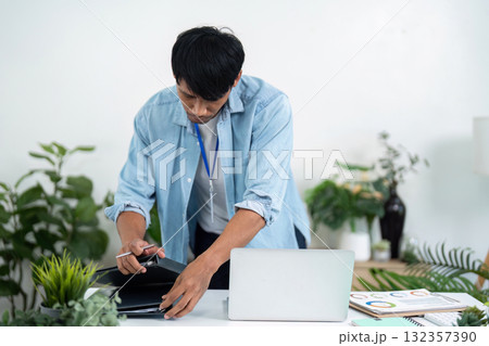 Businessman organizing files and laptop at workspace 132357390