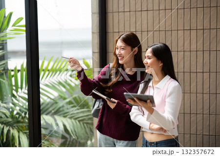 Collaboration and Friendship. Two students interacting in a bright space, excitedly discussing their academic plans. Collaboration and Friendship. Two students interacting in a bright space, excitedly discussing their academic plans. 132357672