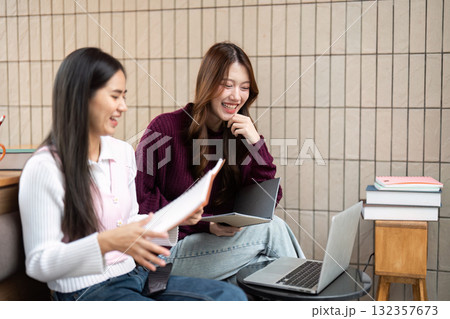 Study Session and Friendship. Friends collaborating on schoolwork, utilizing modern technology in a cozy study spot. Study Session and Friendship. Friends collaborating on schoolwork, utilizing modern technology in a cozy study spot. 132357673