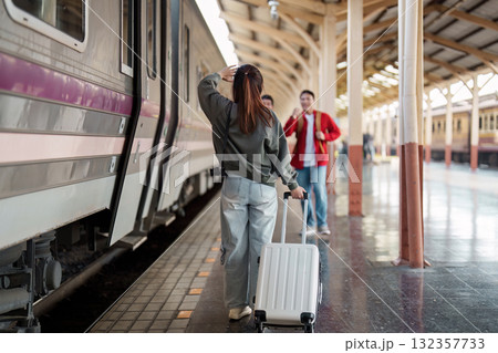 Departure and Anticipation. A woman with a suitcase ready to board her train while friends wave goodbye. 132357733