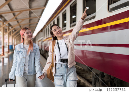 Travel and Friendship. Two friends exploring the train station, excitedly capturing their journey. Travel and Friendship. Two friends exploring the train station, excitedly capturing their journey. 132357781