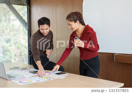 Dynamic UX UI Collaboration. Designers analyzing data and discussing insights while enjoying coffee in a creative space. 132357803