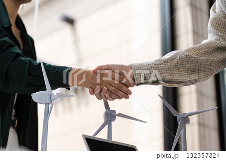 Collaboration and Renewable Energy. Two professionals shaking hands after a successful partnership discussion. Collaboration and Renewable Energy. Two professionals shaking hands after a successful partnership discussion. 132357824