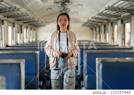 Candid Travel Photography. A confident traveler capturing memories inside a nearly empty train carriage. 132357948
