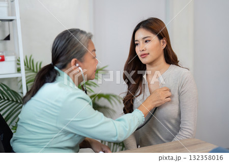 Physical Examination and Patient Interaction. A healthcare professional listens to a patient's heart to ensure overall health checks. 132358016