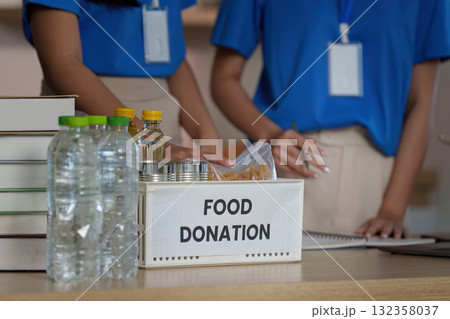 Food Donation Initiative. Volunteers organizing food donations in a community center. 132358037
