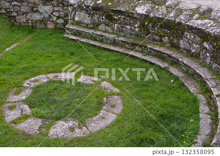 An old stone path in a circular pattern on green grass in a park in Spain. Concept for decorative landscaping and tourism. An old stone path in a circular pattern on green grass in a park in Spain. Concept for decorative landscaping and tourism. 132358095