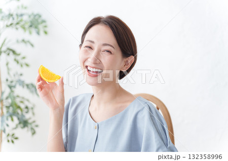 フルーツのオレンジを食べる女性 132358996