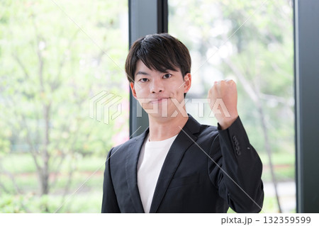 スーツを着た若い20代男性　ガッツポーズ 132359599