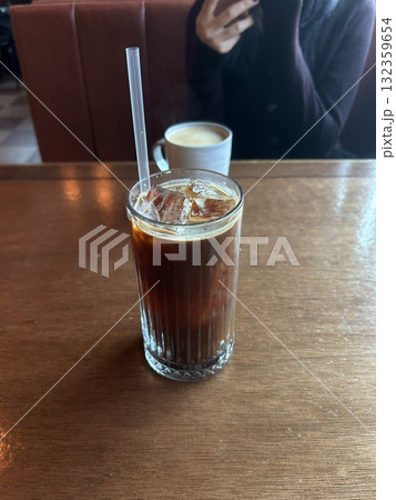 Bold and refreshing iced Americano with smooth espresso and chilled water, offering a rich aroma and deep coffee flavor. A perfect pick-me-up for a crisp and energizing drink. 132359654
