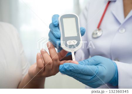 Doctor check diabetes from finger blood sugar level with digital glucose monitor measure and test stripe. Doctor check diabetes from finger blood sugar level with digital glucose monitor measure and test stripe. 132360345