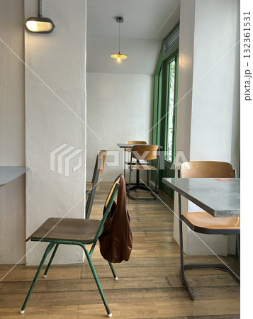 Cozy cafe interior with modern decor, comfortable seating, and warm lighting. A perfect spot for enjoying coffee or tea, creating a relaxed and inviting atmosphere for guests. 132361531